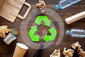 Recycling. Green recycle eco symbol. Recycled arrows sign near matherials for recycle and reuse on dark wooden