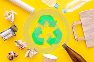 Recycling. Green recycle eco symbol. Recycled arrows sign near matherials for recycle and reuse on yellow background top