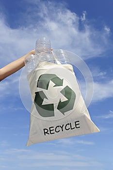 Recycling: hand holding bag with plastic bottles