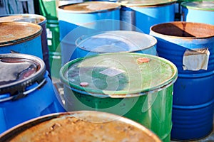 Recycling industry - Rusty metal barrels stacked in rows, toxic waste.