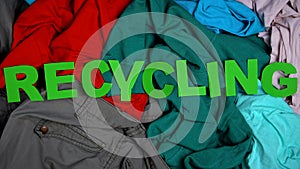 Recycling made of letters on multicolored textile background, overconsumption photo