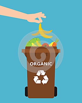 Recycling organic waste. Hand throwing a banana peel into a recycle bin.
