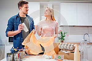 Recycling. Responsible young couple putting empty plastic and paper in garbage bags while looking at each other near the