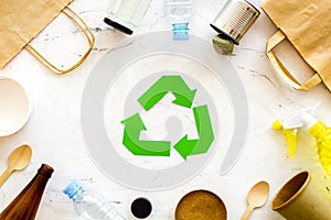 Recycling symbol and different garbage on marble background top view