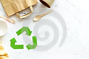 Recycling symbol and different garbage, paper bag, cup, flatware for ecology on marble background top view mock up