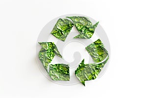 Recycling symbol made of crumpled green paper.