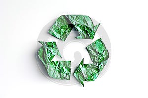 Recycling symbol made of crumpled green paper.