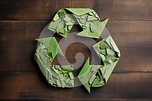 Recycling symbol made of paper against wooden background. Environmental protection, ecology, recycling concept