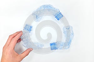 Recycling symbol made of plastic bottles in white background. Flat lay composition. Reduce, reuse, recycle concept.