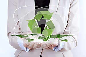 Recycling Symbol over earth map in woman hands