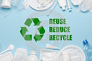 Recycling symbol with reuse reduce recycle slogan surrounded by single-use plastic objects