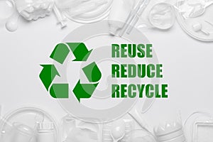 Recycling symbol with reuse reduce recycle slogan surrounded by single-use plastic objects