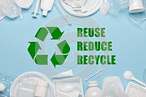 Recycling symbol with reuse reduce recycle slogan surrounded by single-use plastic objects, packaging plastic products