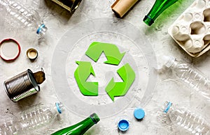 Recycling symbol with waste on gray background top view