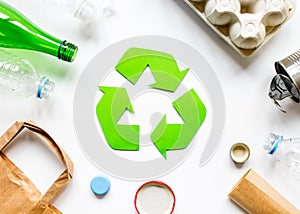 Recycling symbol with waste on white background top view