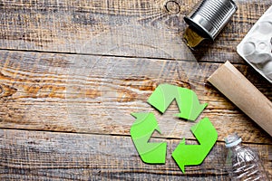 recycling symbol with waste on wooden background top view mockup