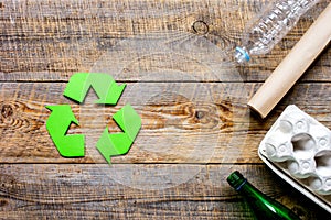 recycling symbol with waste on wooden background top view mockup