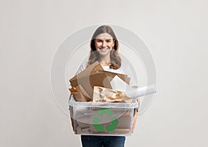 Recycling And Waste Sorting. Smiling Woman Holding Plastic Box With Paper Garbage