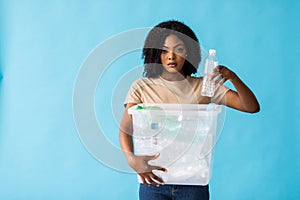 recycling, waste sorting and sustainability concept. Smiling young african american woman holding box with plastic bottles over