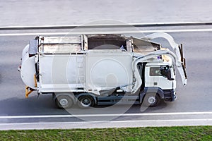 Recycling white truck rides on the road in the city, side view