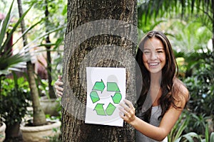 Recycling: woman in forest with recycle sign