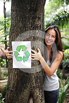 Recycling: woman in the forest with recycle sign
