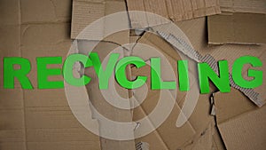 Recycling word made of green letters on cardboard background, save planet