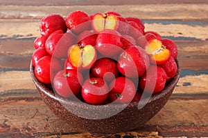 Red acerola - malpighia glabra, tropical fruit in bowl on table