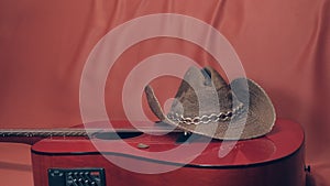 Red acoustic guitar with a cowboy hat on it photo