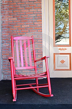 Red adirondack chair on front porch