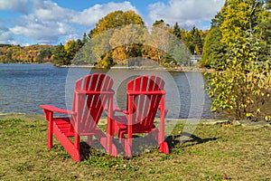 Red Adirondack Chairs on a Lake Shore