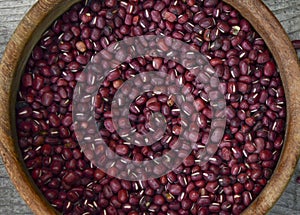red aduki beans in wooden bowl  on wooden floor  viewed from above