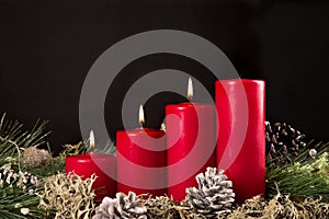 Red advent candles with green pir and pinecone