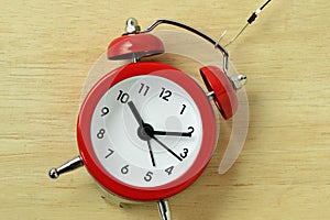 Red alarm clock with fishing hook - Concept of stealing time