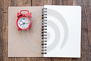 The red alarm clock placed on the cover of the address book for recording. Time management concepts Writing notes at important