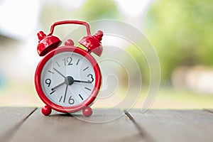 Red alarm clock. Prime time every second.Concept for business deadline, schedule and urgency.Red retro alarm bell clock on old