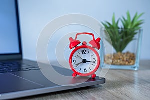 Red alarm clock Put on laptop Concepts for business deadlines, schedules and planning urgency