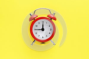 Red alarm clock on a yellow background