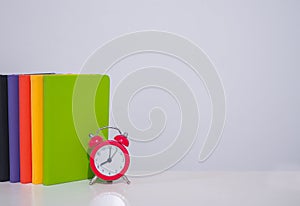 Red alarm and colorful hardcover book, Copy space for text, Back to school, Education concept