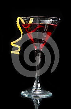 Red alcohol cosmopolitan cocktail decorated with citrus lemon twist