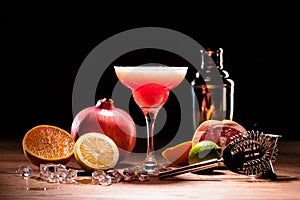 red alcohol margarita drink with fruits on wooden table