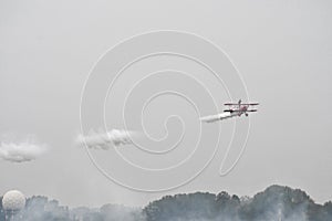 Red antique airplane flying during a grey day