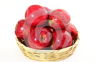 Red apple in bamboo basket on white background