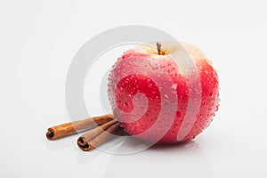 Red apple and cinnamon isolated on white