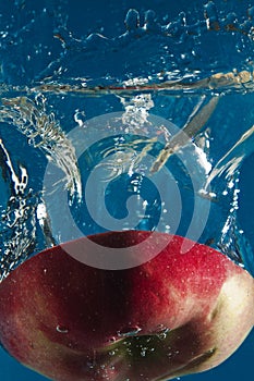 Red apple cut in half in water.