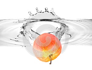 Red apple falling into water