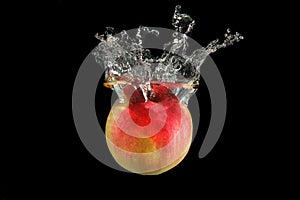 Red apple falling into water