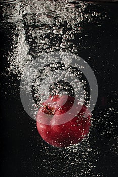 Red apple falling into water