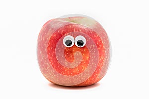 Red apple with googly eyesy on white background - fruit face
