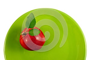Red apple on a green plate